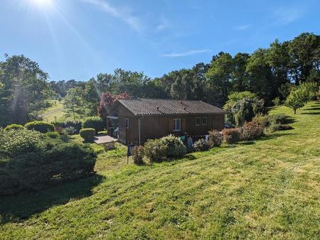 charmante maison en bois entourée par son terrain arboré