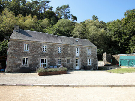 une belle maison de moulin avec un gîte  des chalets en bois et un terrain au bord d'une r