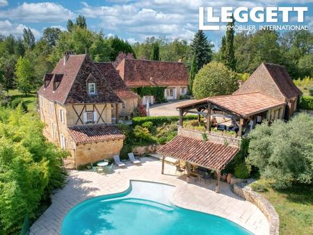 ensemble de trois bâtiments en pierre  piscine  terrasses  prés et forêts.