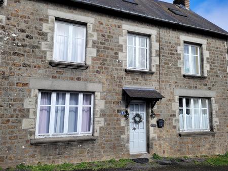 maison traditionnelle en pierre avec jardin et garage